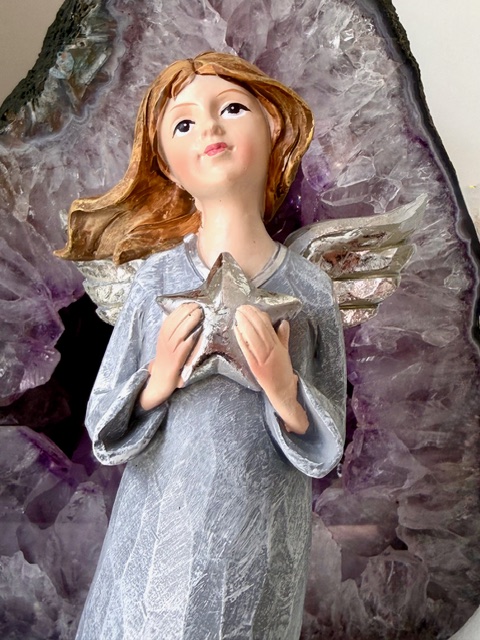 Anděl stojící s hvězdou a stříbrnými křídly