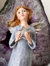 Anděl stojící s hvězdou a stříbrnými křídly